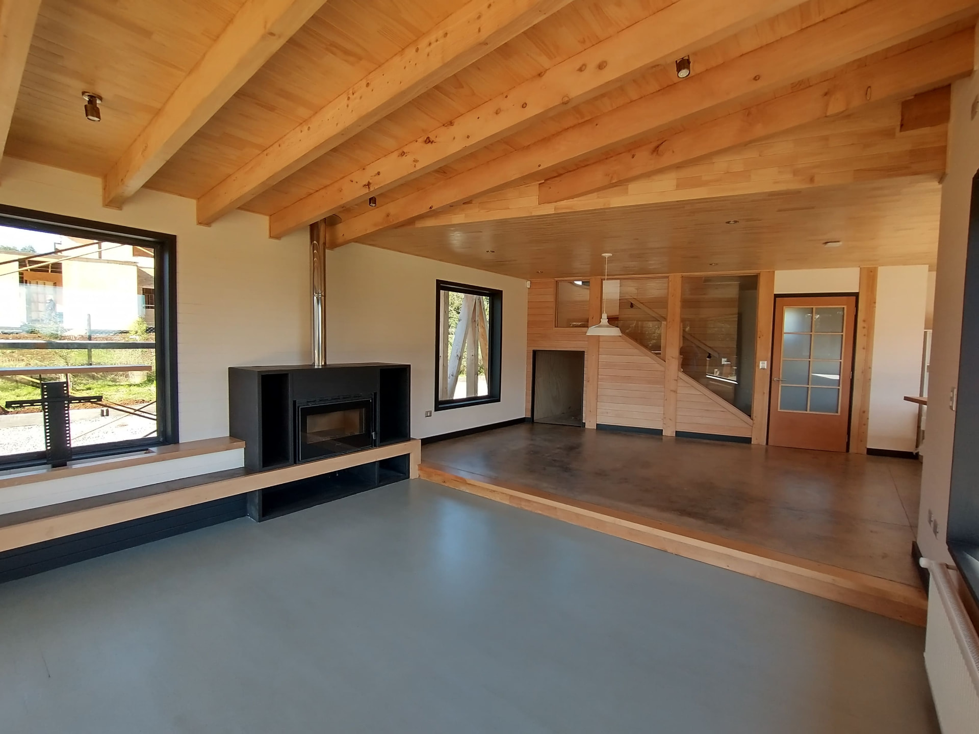 Interior con vigas de madera a la vista y escalera